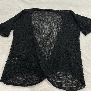 Black iridescent crocheted short sleeve sweater with cross over detail.